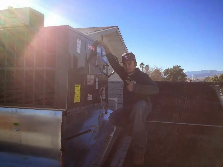HVAC technician performing Heat Pump Repair on a rooftop unit in Dumas